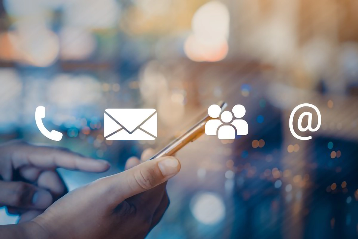 Image of a user holding a smartphone with icons for; phone, mail, group and email